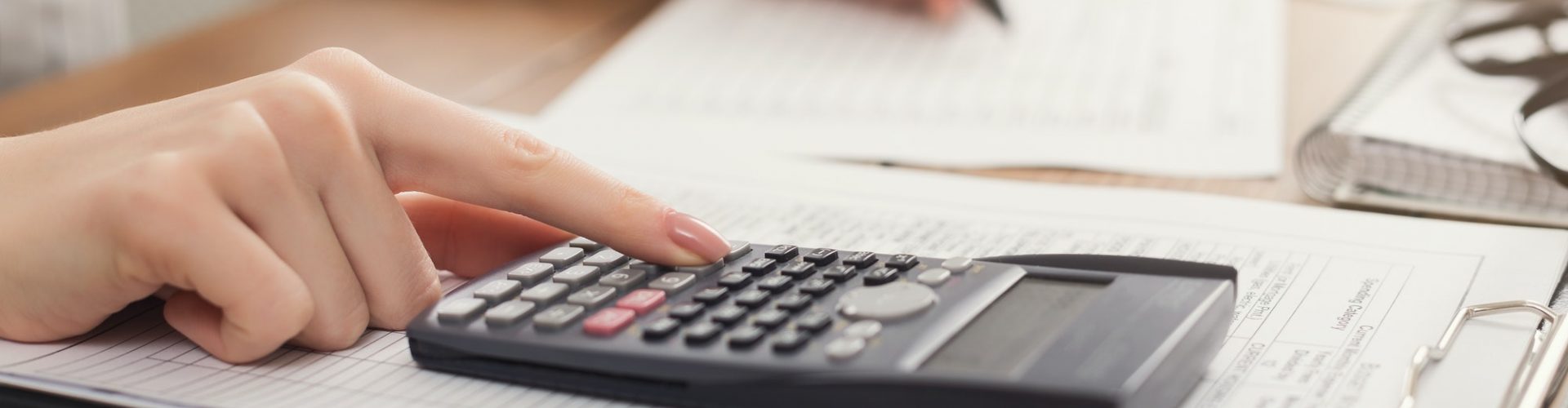 Closeup of woman hands counting on calculator